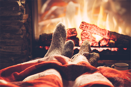 couple feet by the cozy fireplace